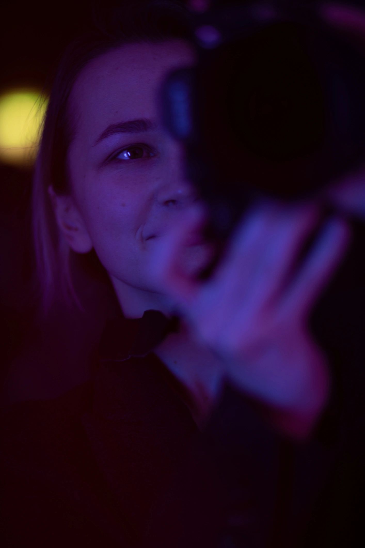 Creator in neon lighting holding a camera, representing confident filming
